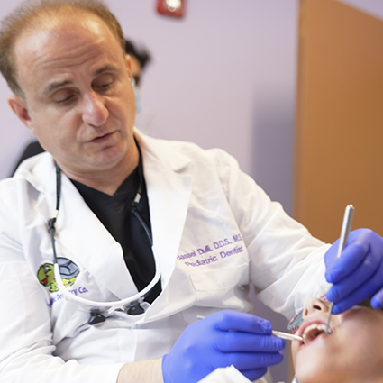 Dentist cleaning a young patient's smile