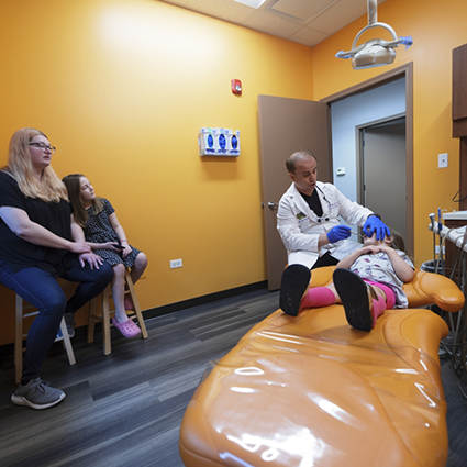Family watching while dentist treats little boy