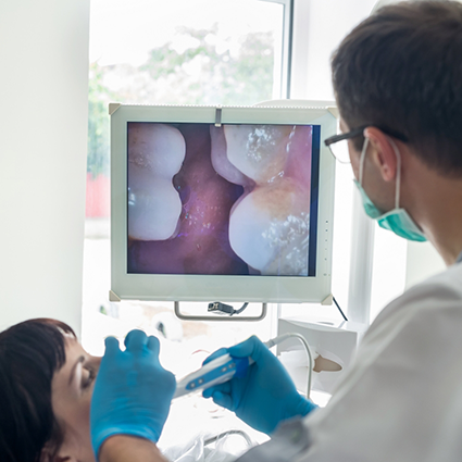 Examining patient's teeth with intraoral camera