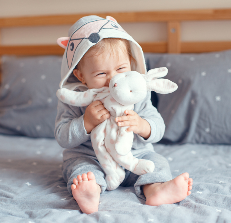 Close up of baby with stuffed rabbit and tiny hoodie