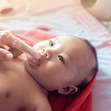 Close up of baby having teeth brushed