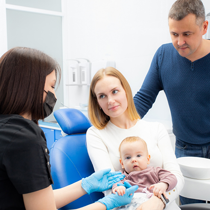 Mother with baby visiting pediatric dentist