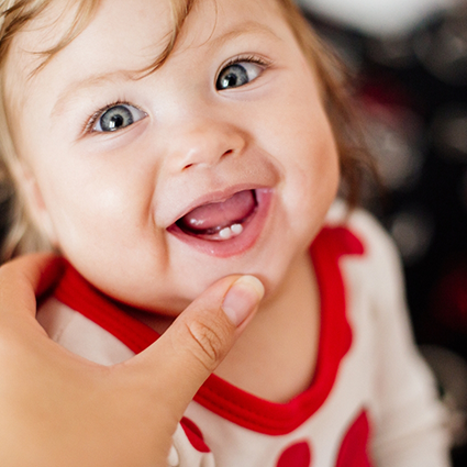 Child opening mouth to show first two teeth