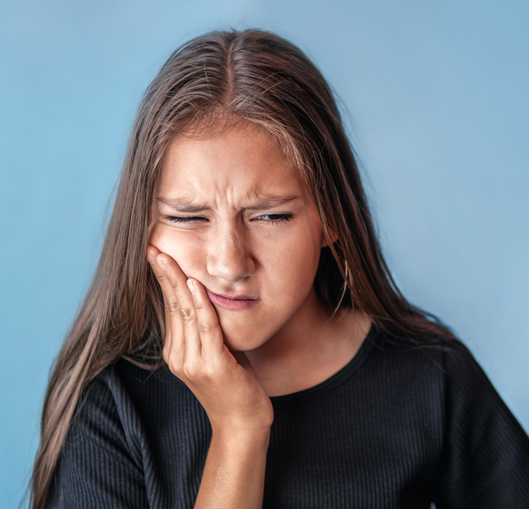 Close-up of young girl with tooth pain