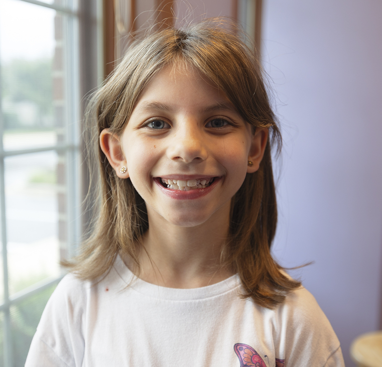Close up of little girl in white shirt smiling