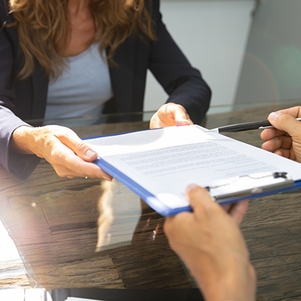 Dental team member handing clipboard to patient