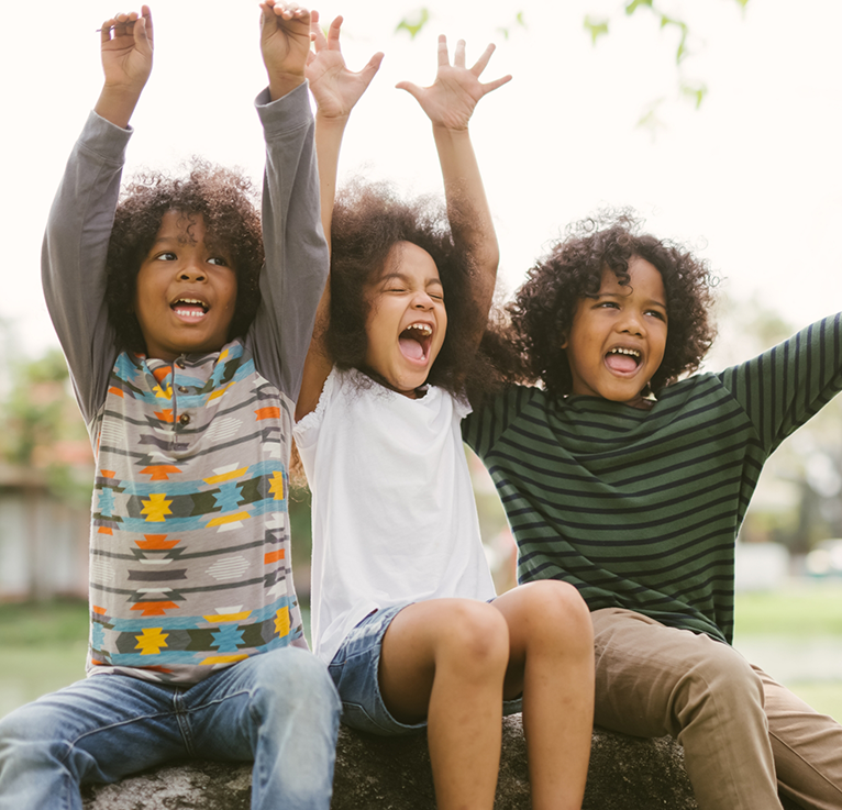 Young children throwing up their arms and yelling