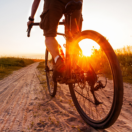 Biking down a dirt trail at sunset