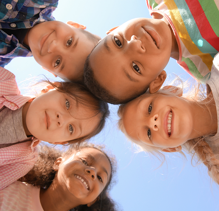 Smiling children in a circle looking down