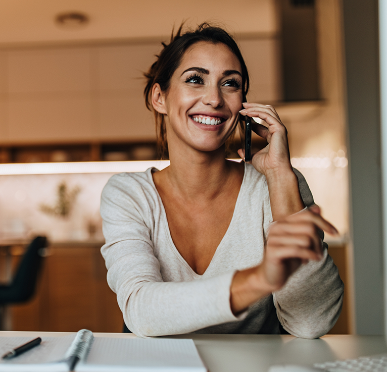 Close up of woman at desk talking on phone