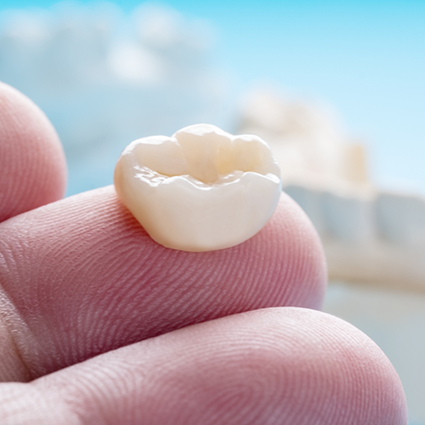 Dental crown sitting on top of a finger