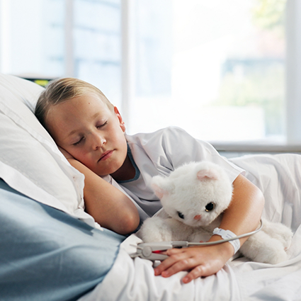 Little boy with stuffed bear sleeping in bed