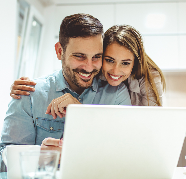 Smiling man and woman looking at laptop