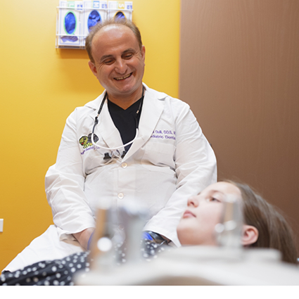 Naperville pediatric dentist smiling down at patient