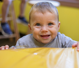 Smiling toddler playing on couch