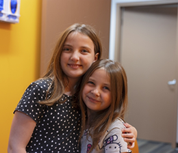 Little girls side hugging in dental office